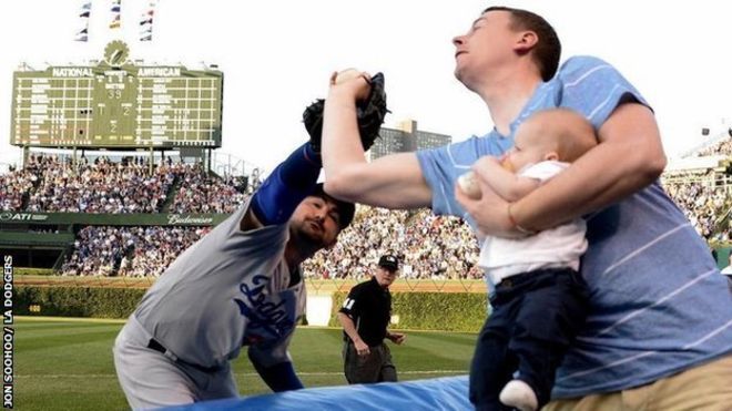 La impresionante atajada de béisbol de un papá alimentando a su bebé