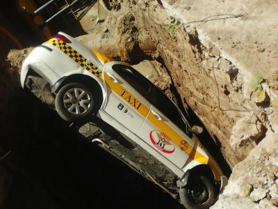 Taxi cayó dentro de profundo pozo de obra de saneamiento en Goes