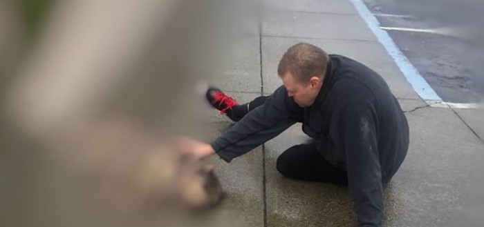 Un hombre se sienta en la calle y consuela a un perro atropellado en plena agonía